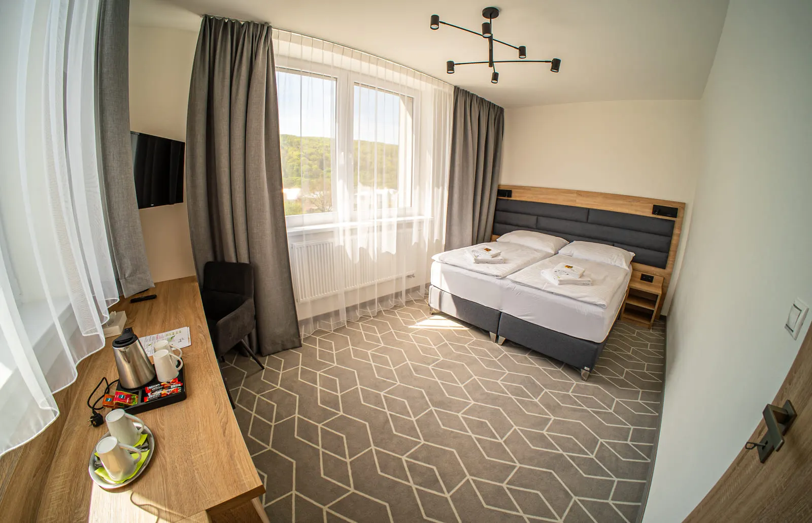 Manželská posteľ v suite s výhľadom na mesto